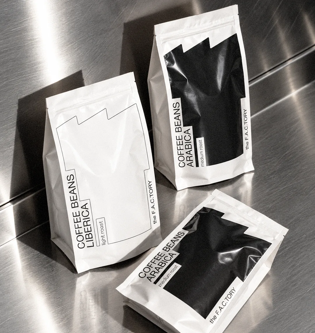The F.A.C.Tory coffee packaging featuring black and white industrial-inspired graphics